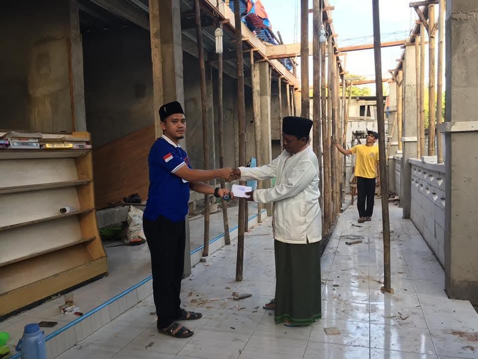 Handing over a donation to the imam at a mosque under renovation